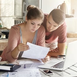 Couple looking over bills at kitchen counter