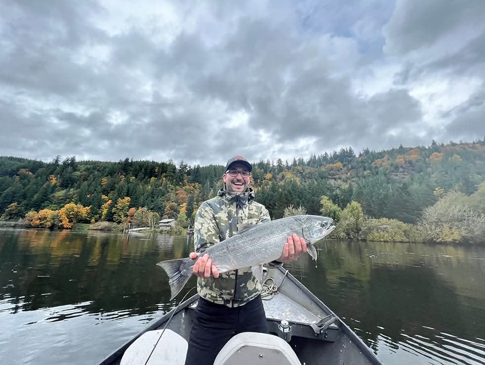 Man in boat holding out fish for camera