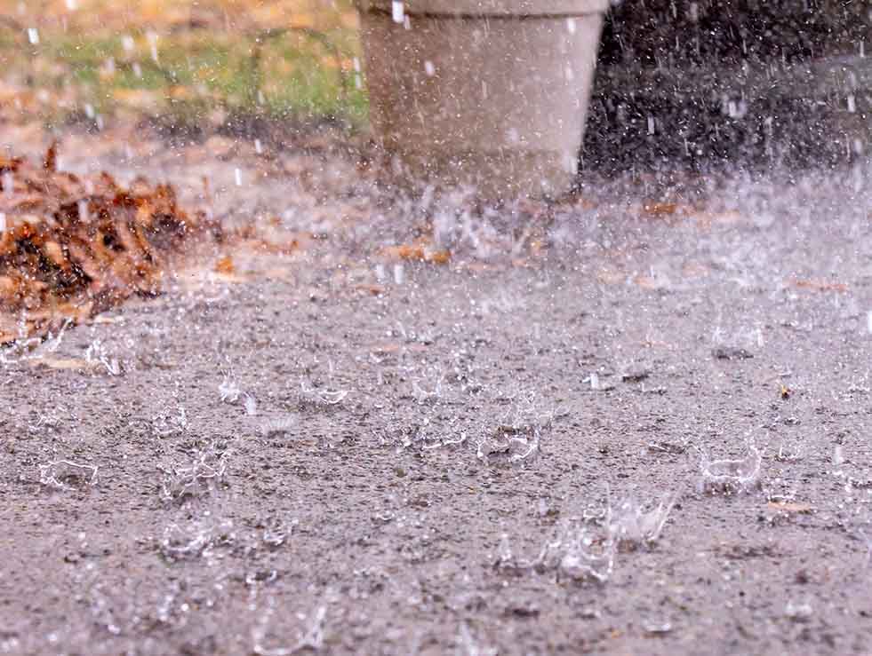Closeup of rain drops falling on concrete patio