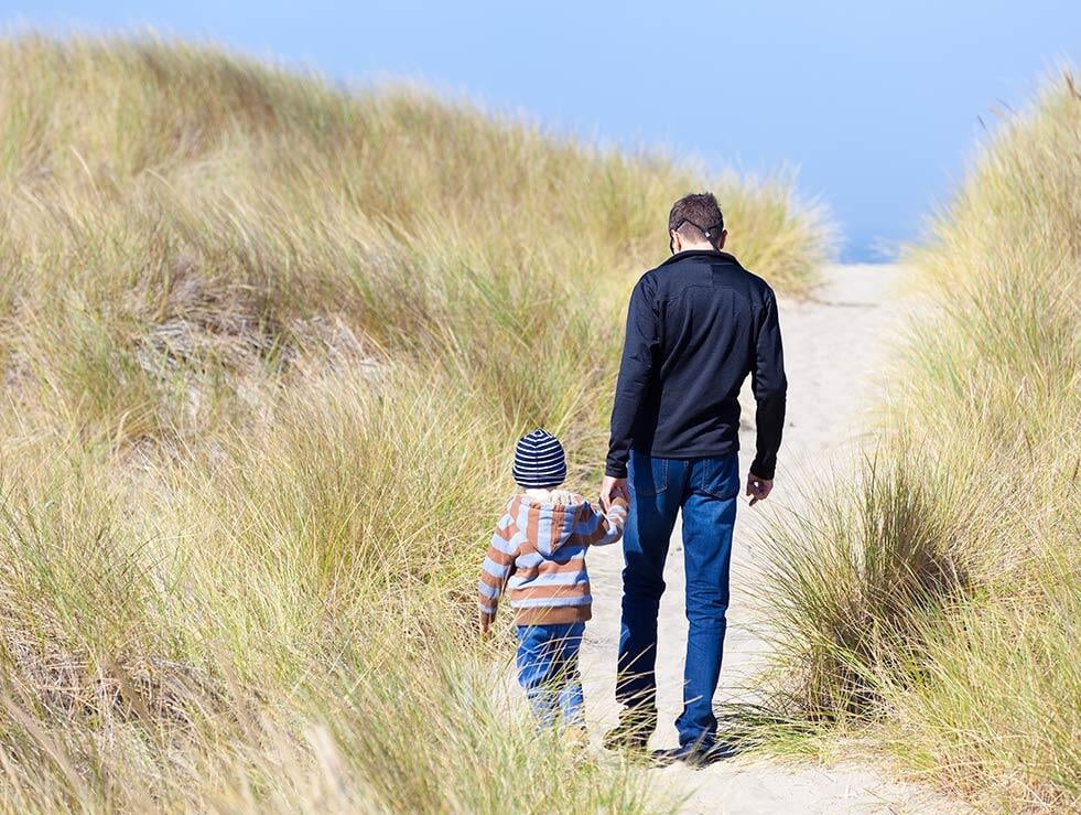 Father and son walking in sand