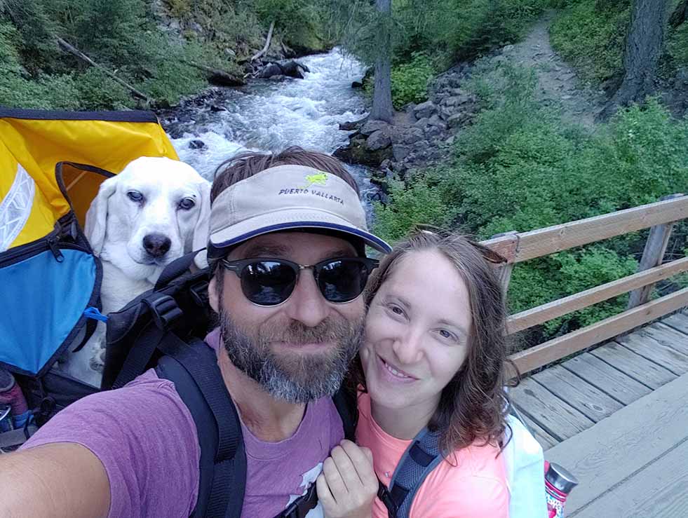 Two Oregonians hiking with their dog in a backpack